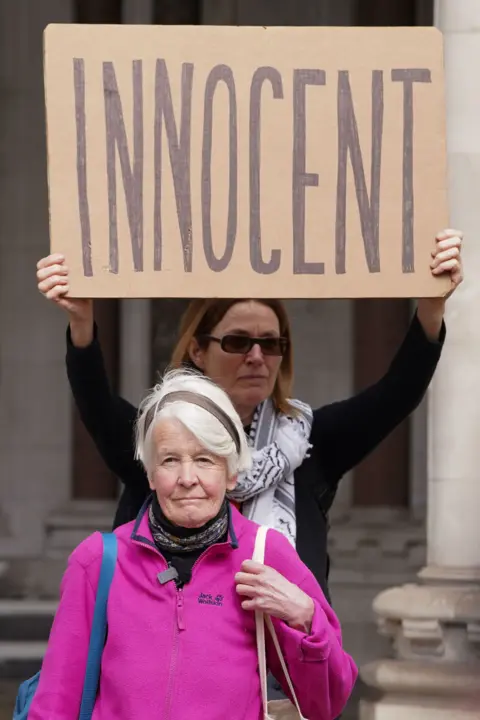 PA Trudi Warner outside the Royal Courts of Justice in London with an 'innocent' sign behind her