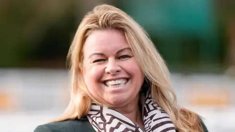 Sandown Park A woman with long blonde hair smiling at the camera
