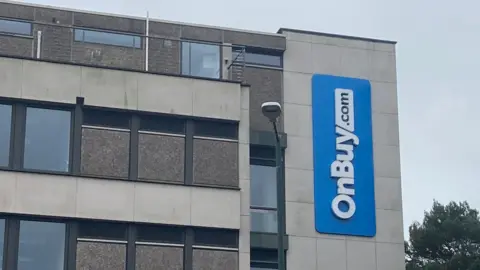 A five-storey office block with a blue OnBuy sign on the side