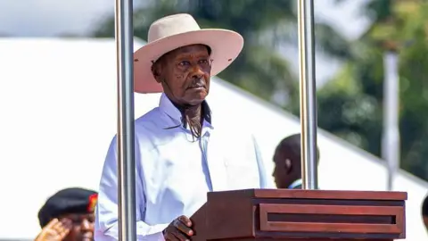 Uganda's President Yoweri Museveni in a white shirt and white wide-brimmed hat