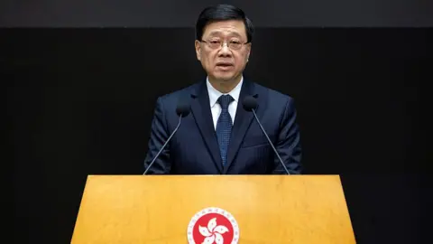 Getty Images John Lee, Hong Kong's chief executive, speaks during a news conference in Hong Kong on 2 December 2025.