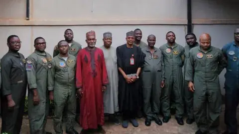 Nigeria’s foreign affairs ministry Nigeria’s foreign affairs minister dressed in traditional kaftan with 11 uniformed officers of his country Air force detained in Burkina Faso