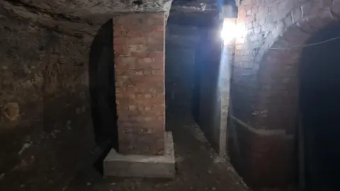 Supplied A view of a cave with a brick pillar in the foreground.
