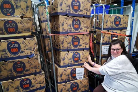 LDRS/Paula Clarke Paula Clarke with wholesale boxes of bananas stacked up on trolleys.