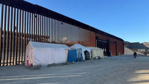 Tents at a border wall