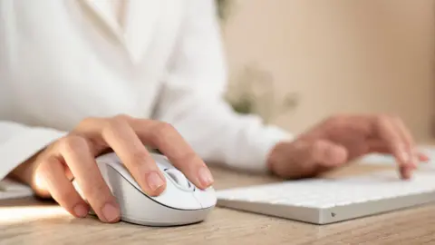 Getty Images Stock image of person using a computer mouse and keyboard.