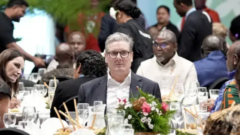 Prime Minister Sir Keir Starmer sits at a dining table as he attends a Welcome Reception and State Banquet at Apia Park during the Commonwealth Heads of Government Meeting in Samoa on 24 October 2024