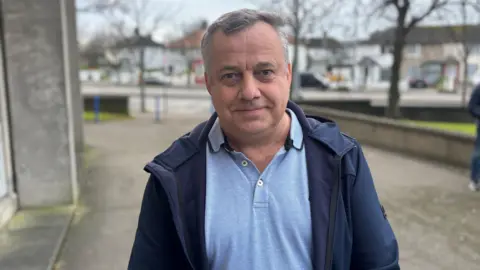 Ukrainian man wearing a blue jacket smiles at the camera