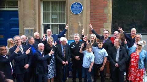 Trustees from the Sheffield Home of Football next to a blue plaque after its unveiling in the city.