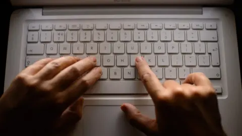 Hands on a laptop keyboard.