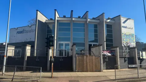 The glass and painted white brick exterior of Northampton's Roadmender music venue as seen on a bright sunny day