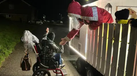 Caernarfon Round Table Santa shaking hands with a young visitor