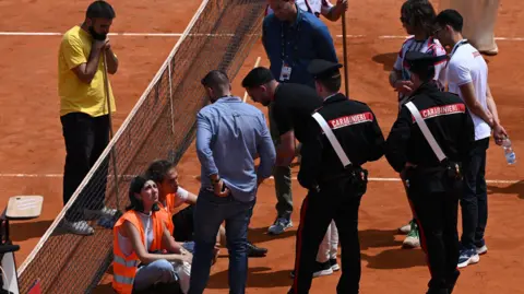 Protesters cause a delay to a doubles match at the Italian Open