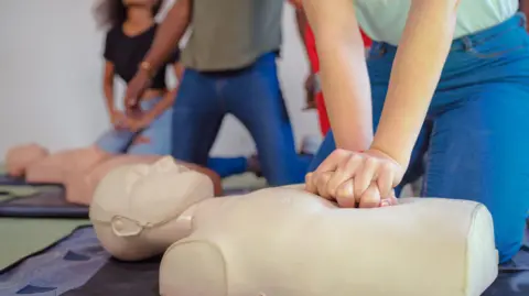 Hands of a trainee doing chest compression during defibrillator CPR Training. 