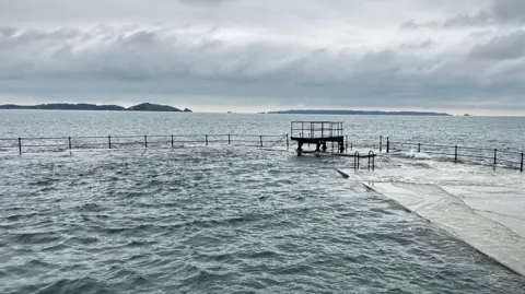 A Victorian outdoor bathing pool by the sea with a small diving pool on one wall.