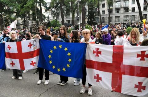 Protesters in Georgia holding up the Georgian flag and the EU flag