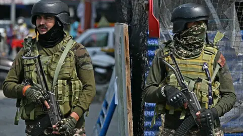 AFP via Getty Images Indian paramilitary personnel stand guard along a road in Srinagar on May 7, 2025, following border tensions. India and Pakistan exchanged heavy artillery along their contested frontier on May 7, after New Delhi launched missile strikes on its arch-rival in a major escalation between the nuclear-armed neighbours. New Delhi announced it had carried out "precision strikes at terrorist camps" at nine sites in Pakistan-administered Kashmir, days after it blamed Islamabad for a deadly attack on the Indian-run side of the disputed region. (Photo by Sajjad HUSSAIN / AFP) (Photo by SAJJAD HUSSAIN/AFP via Getty Images)