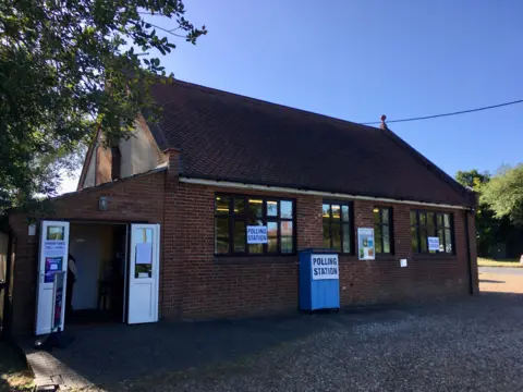 Red brick polling station with signs outside