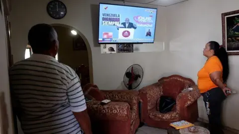 Nicole Colter/BBC Mundunde Mirelis Cassic Lopez está assistindo televisão com sua família em Maracilo, na Venezuela. 