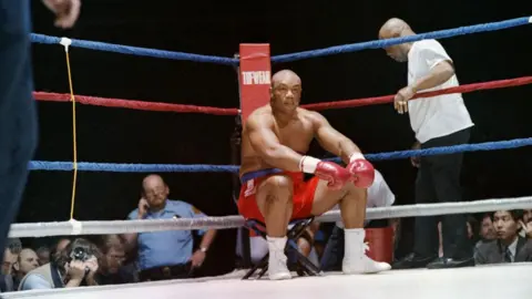 Carlos Speck/AFP via Getty Images Foreman sat inside the ring