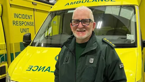 EMAS Dave Turner stood in front of ambulance