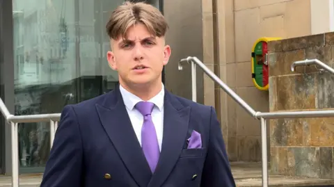 George Finch stood at the council house steps wearing a navy suit and purple tie