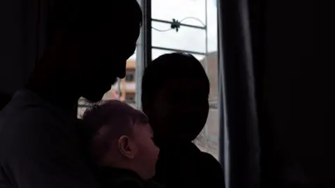 BBC/ Jonathan Head A resistance fighter, his child and wife in Mae Sot Thailand that borders Myanmar.