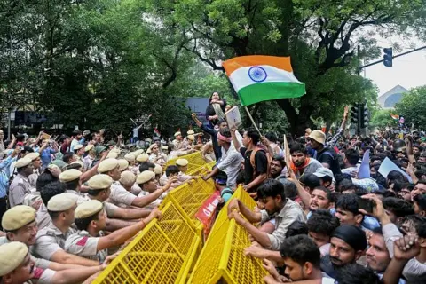 Getty Images Activists and supporters of the Cockroach Janta Party (CJP) clash with police personnel during a protest demanding the resignation of India's Education Minister Dharmendra Pradhan over alleged NEET examination irregularities in New Delhi on July 20, 2026.