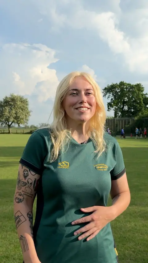 Cricketer Georgia Inkley smiles on the pitch.