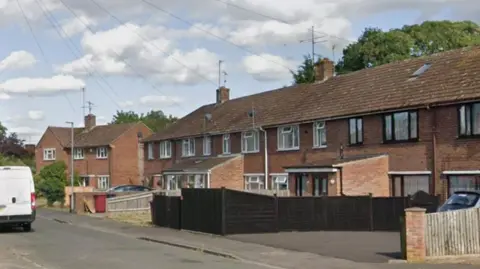 A row of terraced houses in a residential cul-de-sac. 