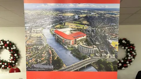 A image displayed on an advertising banner inside a conference room at the City Ground. The image shows a digital illustration of a proposed, revamped City Ground.