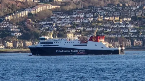 Christopher Brindle A black and white ship with red funnels sailing along a river with houses on the hillside in the background