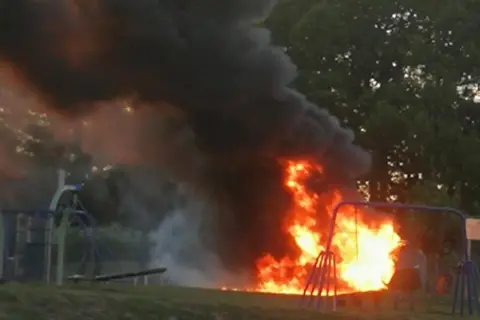 Peter Ellis/Our Bassetlaw A fire burning in the centre of a playground with a thick plume of smoke rising up