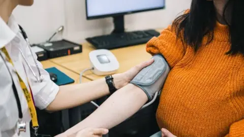 Getty Images Generic image of a doctor taking a pregnant woman's blood pressure.