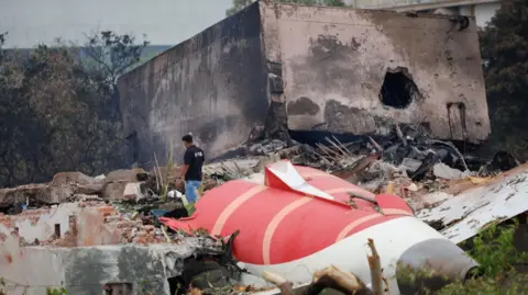 Reuters A firefighter stands next to the crashed Air India Boeing 787-8 Dreamliner aircraft, in Ahmedabad, India, June 13, 2025.