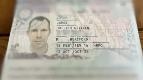 Tony Fisher/BBC Close-up of an open British passport showing a photo ID page with a portrait illustration and printed personal details, with the page edges slightly out of focus.