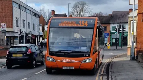 BBC An orange Leicester Centrebus bus on a city street