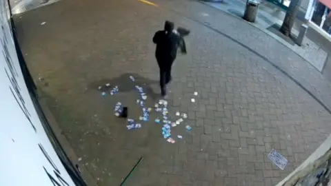 Thief leaving shop with hundreds of trading cards