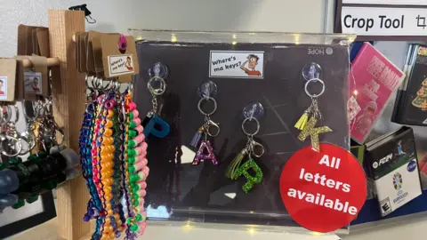 A display of key chains. Some of the key chains have letters and they are various colours. The branding says Where's ma keys?