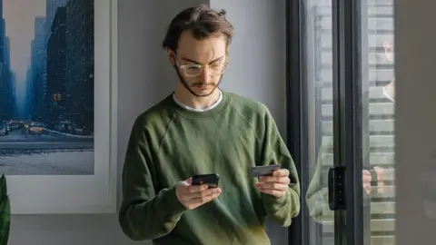 Man using online banking app in living room