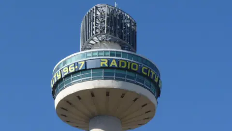 A close up of the tower. It has Radio City 96.7 wrapped around the top in yellow lettering.