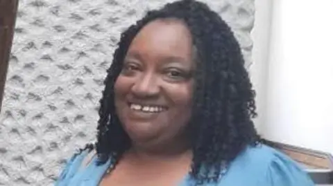 Sheffield foster carer Marcia Grant, a woman with black braided hair wearing a blue shirt.
