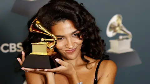 EPA/Shutterstock Olivia Dean holding Grammy.