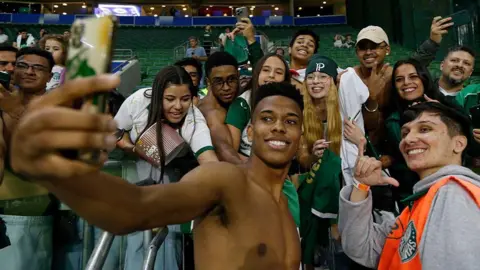 Estevao Willian poses for a selfie with a group of Palmeiras fans