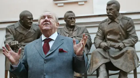 Getty Images Tsereteli stands in front of his statue of the three leaders