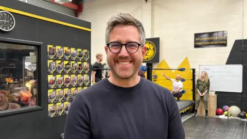 Professor Andy Kesson, from the University of Roehampton, smiling at the camera while attending rehearsals.