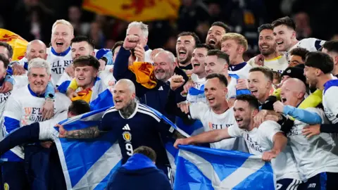 PA Media Scotland players celebrating after securing qualification for the country's first men's World Cup since 1998. 
