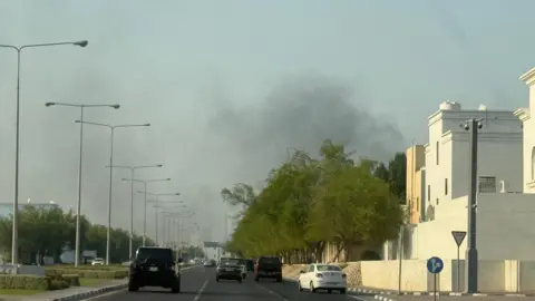 Reuters A road stretching ahead in Doha with smoke rising in the distance shortly after blasts were heard. 