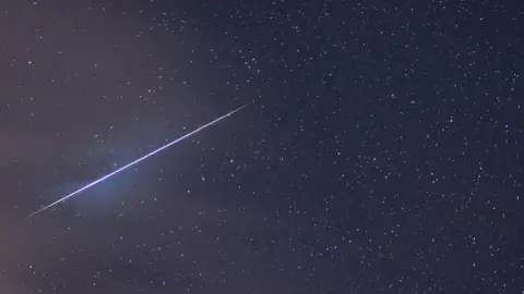 Dan Monk, Kielder Observatory A blue shooting star blazes a trail across the night sky during the Geminid meteor shower