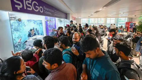 Hindustan Times via Getty Images Passengers seen in heavy rush and chaos at the IndiGo counter at Indira Gandhi International Airport Terminal 1 on 4 December
